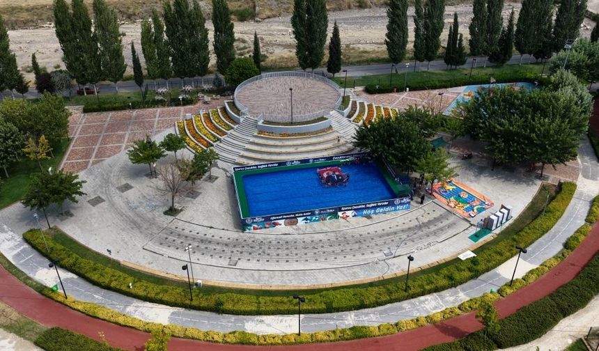 Kula Belediye Meydanına kurulan portatif havuzda, çocuklar yüzme öğrenip serinliyorlar